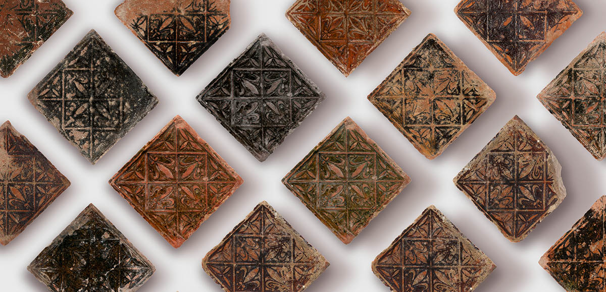 An arrangement of tiles from Butley Priory showing Fleur-de-lis and petals in squares and triangles